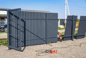 Uzhgorod, Ukraine - August 25, 2022: Installation of metal gates. Gate from a profile pipe in the process of assembly at a construction site.