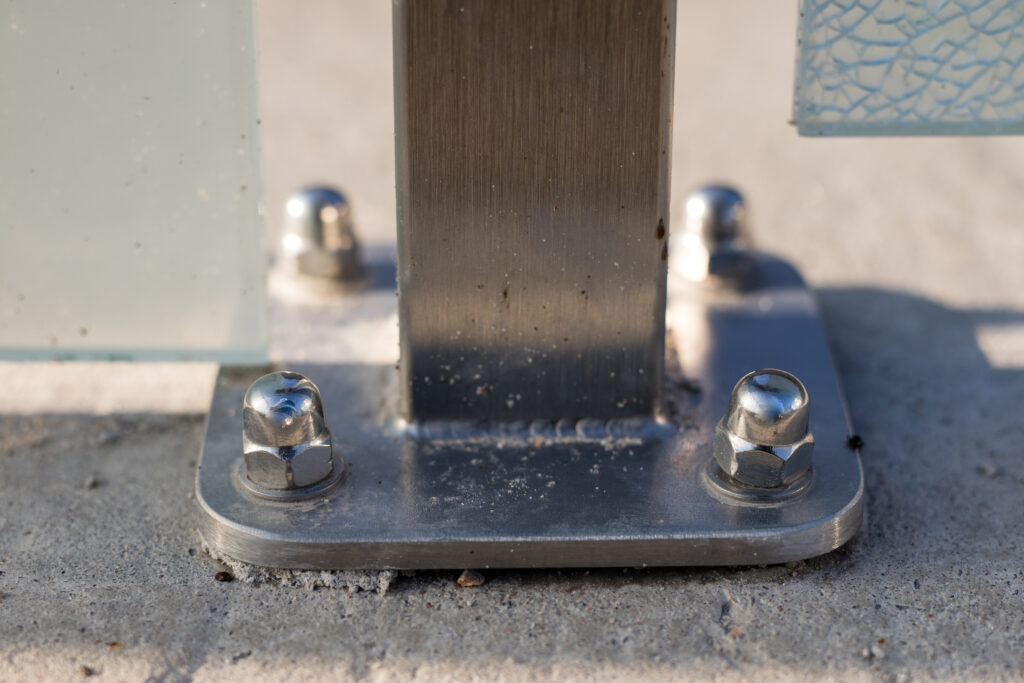 Nut and washer attached to the steel structure. Fixing of steel supports for concrete foundations. Season of the spring.